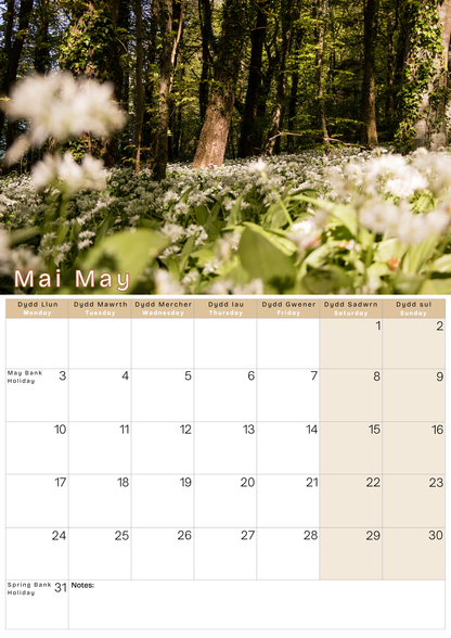 Calendar with a forest and flower background, displaying the month of May.
