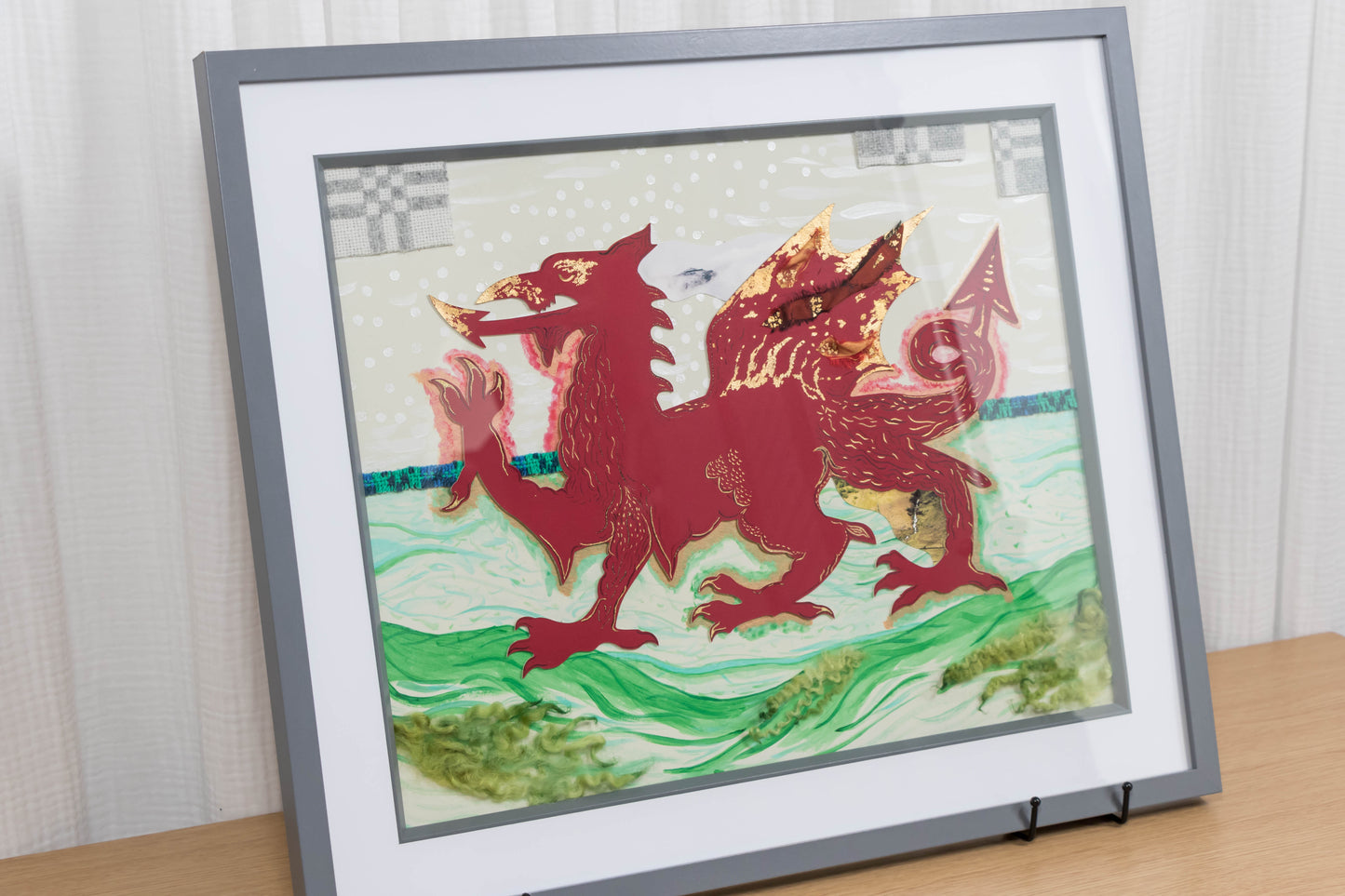 Framed mixed media artwork of a red dragon on a white and green background