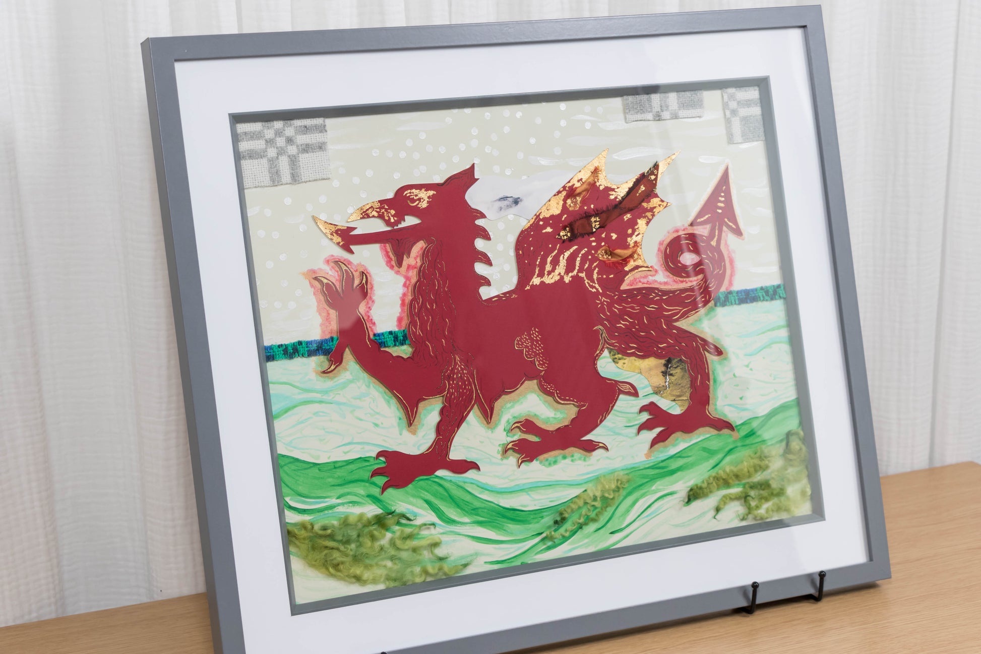 Framed mixed media artwork of a red dragon on a white and green background