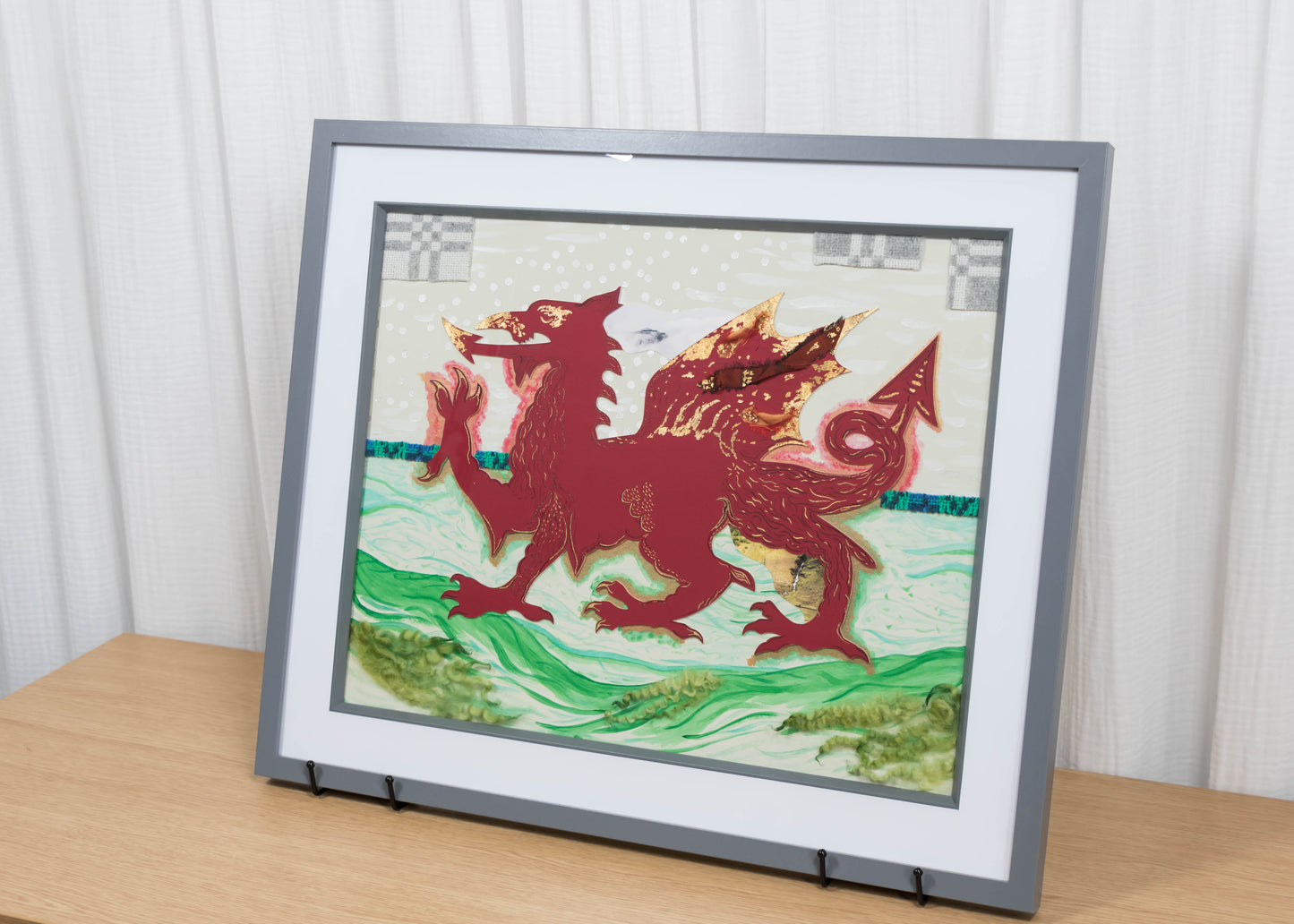 Framed mixed media artwork of a red dragon on a white and green background