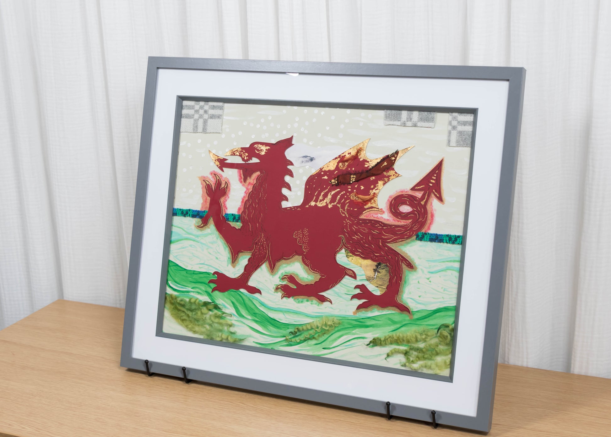 Framed mixed media artwork of a red dragon on a white and green background