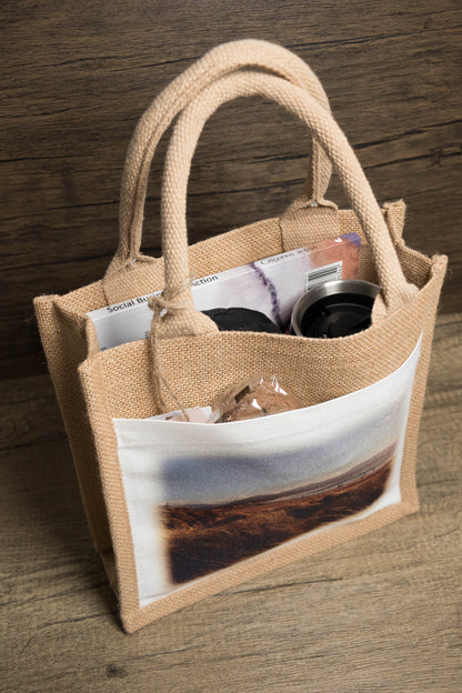 jute bag filled with a book pencil case and drink flask