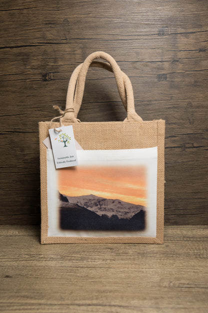 Jute bag with a printed a sunrise landscape of Yr Wyddfa/ Snowdon with a ticket that says sustainable jute ethically produced.